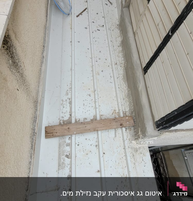 גג מתכת לבן עם לכלוך וקרש עץ